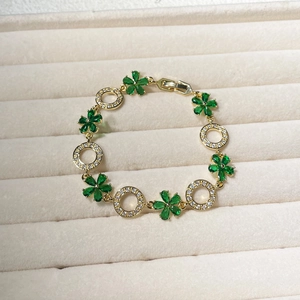 Detailed close-up of emerald green zircon flower bracelet in a beige velvet jewelry box