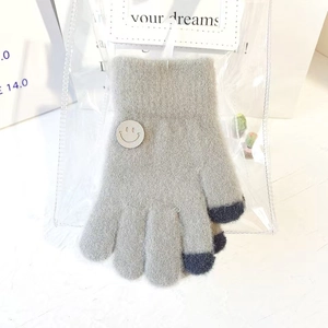 Close-up of grey knitted gloves with yellow smiley patch and touchscreen fingertips
