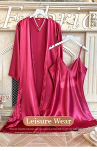 Detail of burgundy satin pajama set featuring a V-neck chemise and lace-up robe on a hanger