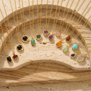 Detailed view of 18K gold plated heart and gemstone pendants on fine cuban chains