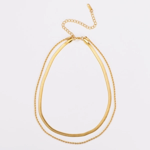 Detailed close-up of double-layered golden snake chain and twisted rope link necklace