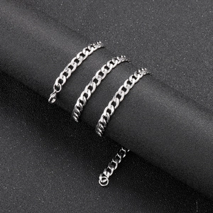 Close-up of 6mm silver curb chain with lobster clasp on textured black cylinder