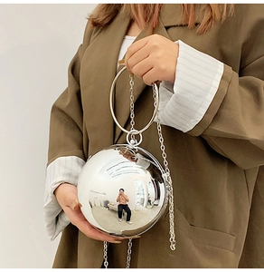 Dettaglio della borsa da sera sferica argento con manico ad anello e finitura a specchio