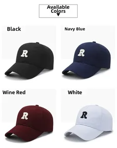Detail view of cotton baseball caps with R letter embroidery in four distinct colors