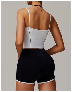 Rückansicht eines weißen Yoga-Tops mit schwarzen Trägern und passenden Sport-Shorts