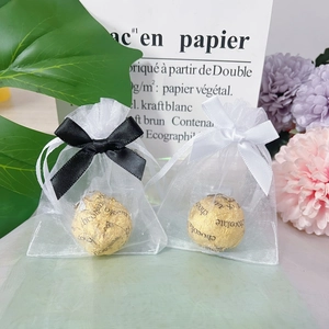 Mini white organza gift bags with silk ribbon bows and gold foil chocolates