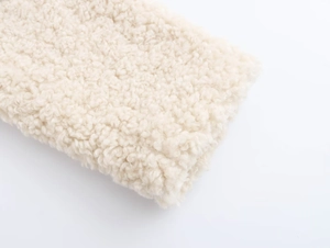 Detailed close-up of fluffy cream faux fur texture on a stylish women's winter coat