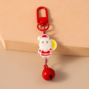 Close-up of a festive Christmas keychain with Santa Claus pendant and a red jingle bell