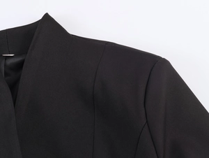 Close-up of the elegant mandarin collar and shoulder tailoring on a black blazer