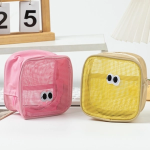 Detail of pink and beige mesh cosmetic bags featuring cute large eye embroidery