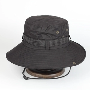 Detail view of black outdoor sun hat featuring metal vents and adjustable wind rope
