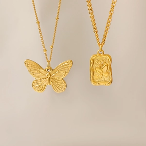 Detail of 18K gold plated square pendant and butterfly charm on vintage necklaces