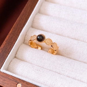 Detail of 18k gold plated tiger eye ring with black bead in a velvet jewelry box