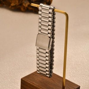 Silver stainless steel president link bracelet watch band on a luxury display stand