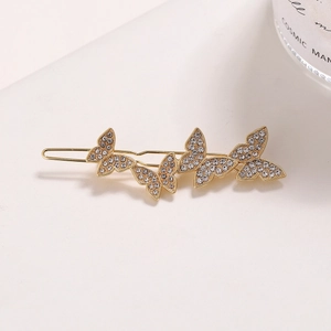 Elegant gold butterfly hair clip with sparkling rhinestones in a minimalist design