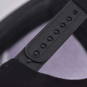Detail of adjustable black plastic snapback closure on classic cotton baseball cap