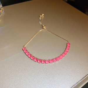 Détail d'un bracelet bolo en or rose avec pierres d'opale rose et fermoir coulissant