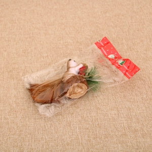 Close-up of decorative Christmas foam squirrel on wooden base with pine needles and berries