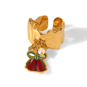 Detail of gold Christmas open ring with bell and pearl pendant on a white background