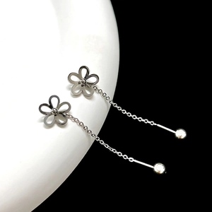 Dettaglio macro di orecchini a fiore d'argento con nappa su base di ceramica