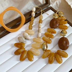 Detail of acrylic irregular beads and gold metal spacers in necklace and bracelet set