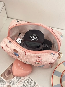 Close-up of pink quilted doll makeup bag showing storage capacity and cute cartoon patterns