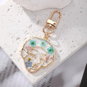 Creative profile silhouette keychain with colorful dried flowers in golden resin frame