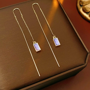 Detailed close-up of gold long chain earrings featuring purple enamel rectangular pendants