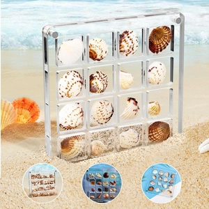 Detailed view of a 16-slot transparent acrylic shell storage box on a beach background