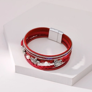 Detail of red multilayer leather bracelet with silver starfish and turtle charms