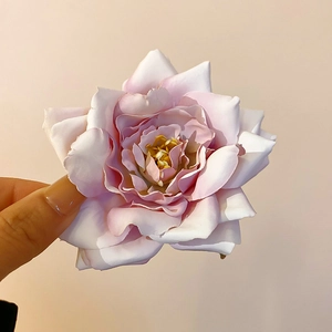 Close-up of a pink fabric rose hair clip showing delicate petal textures and gradients