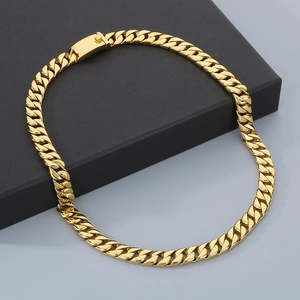 Detail shot of golden 12mm Cuban link chain necklace on a premium black jewelry gift box