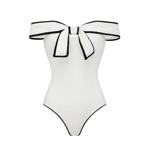 Detail view of one-piece swimsuit featuring a large bow and elegant off-shoulder design