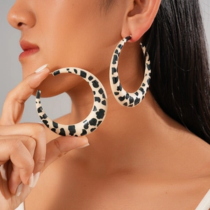 Chic black and white cow print large hoop earrings shown on a model for a stylish look