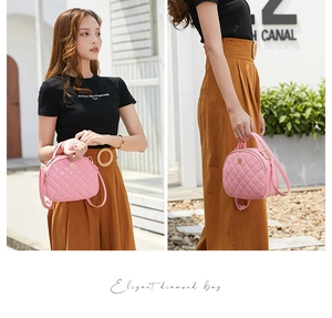 Pink diamond quilted leather handbag with clover buckle shown in a street style view