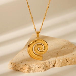 Elegant 18k gold plated stainless steel spiral pendant necklace on a natural stone base