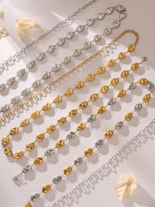 Detailed view of hollow abstract face metal chain links in gold and silver finish