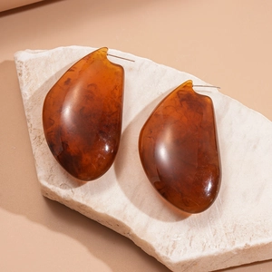 Vue détaillée de boucles d'oreilles en résine ambre avec texture écaille de tortue