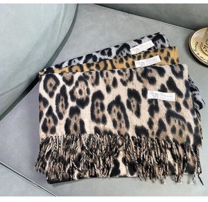 Detailed macro view of folded leopard print cashmere scarves with soft fringed edges