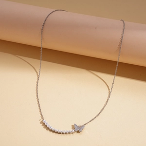 Close-up of elegant silver butterfly pendant with pearls and zircon details