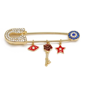 Detail of gold safety pin brooch with devil eye charms and sparkling rhinestones