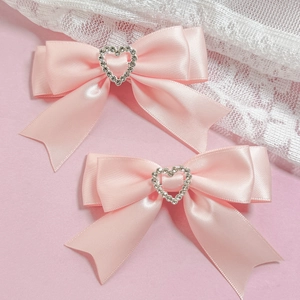 Détail de nœuds en satin rose avec des centres en strass argentés étincelants en forme de cœur
