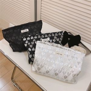 Detailed view of three heart jacquard makeup bags with simple wish labels in a gift setting