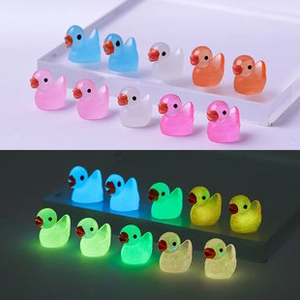 Luminous mini resin ducks in various colors showing glow-in-the-dark effect for desk decor