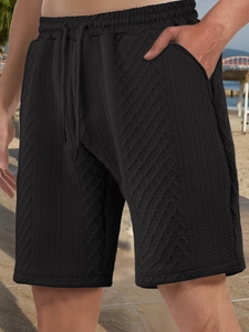 Detail of men's black waffle textured casual shorts with drawstring waist and pockets