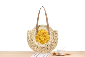 Detailed view of handmade circular straw bag with fried egg design and brown leather straps