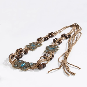 Detail of bohemian braided waist belt with bronze butterfly charms and blue gemstones