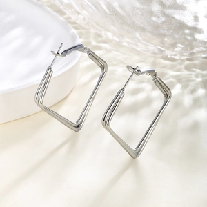 Detailed close-up of double-layered silver geometric earrings with a high-polished finish
