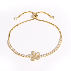 Détail d'un bracelet doré ajustable avec fleur en zircon et fermoir à glissière