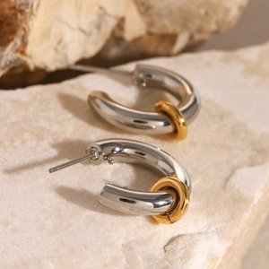 Macro detail of two-tone gold and silver C-shaped stainless steel chunky stud earrings